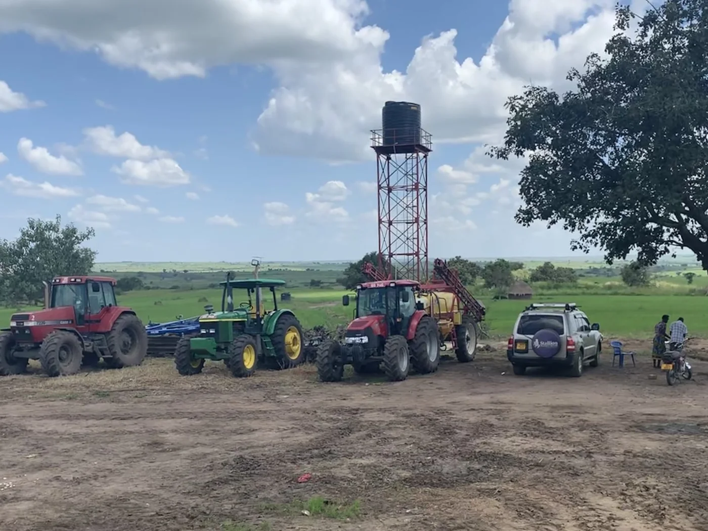 Normah staff gathered beside the farm's tractor fleet and water tower.